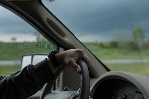 Driver Holding Steering Wheel in Rainy Conditions Driver Holding Steering Wheel in Rainy Conditions