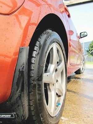 Low-angle close-up of a red vehicle’s rear wheel and tire