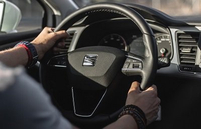 Close-up view of a vehicle interior showing a person’s hands