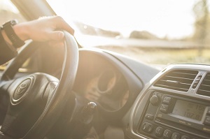 Interior view of a vehicle with a driver’s hand on the steering wheel