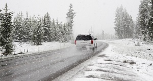 Vehicle driving on a snow-covered road during active snowfall