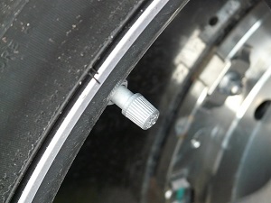 Close-up view of a vehicle tire valve stem on a wheel rim