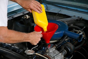 a mechanic pouring oil in the engine a mechanic pouring oil in the engine