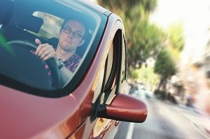 View of a person driving a red vehicle