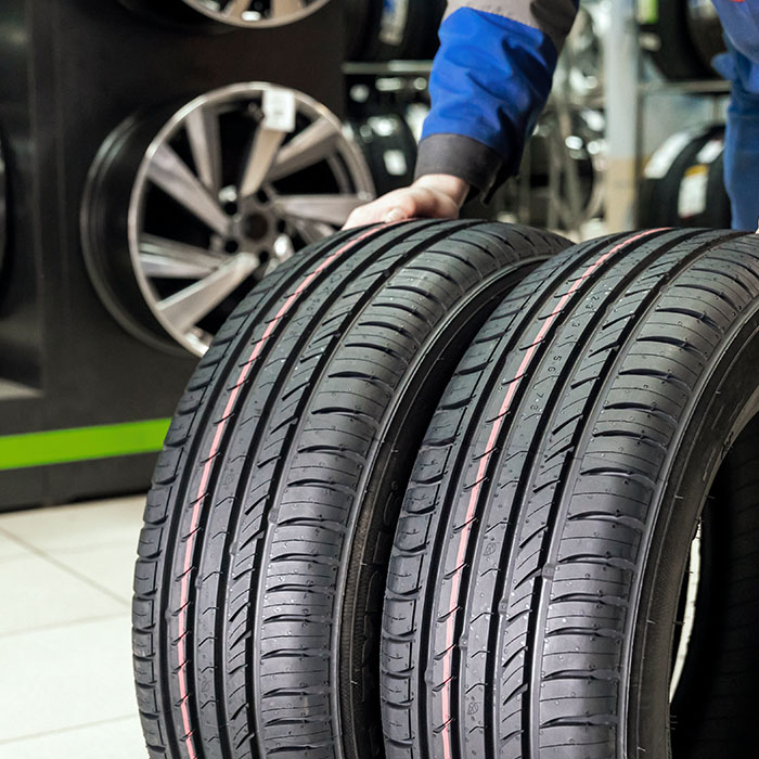 The seller rolls a pair of new tires for the season to the store's exit