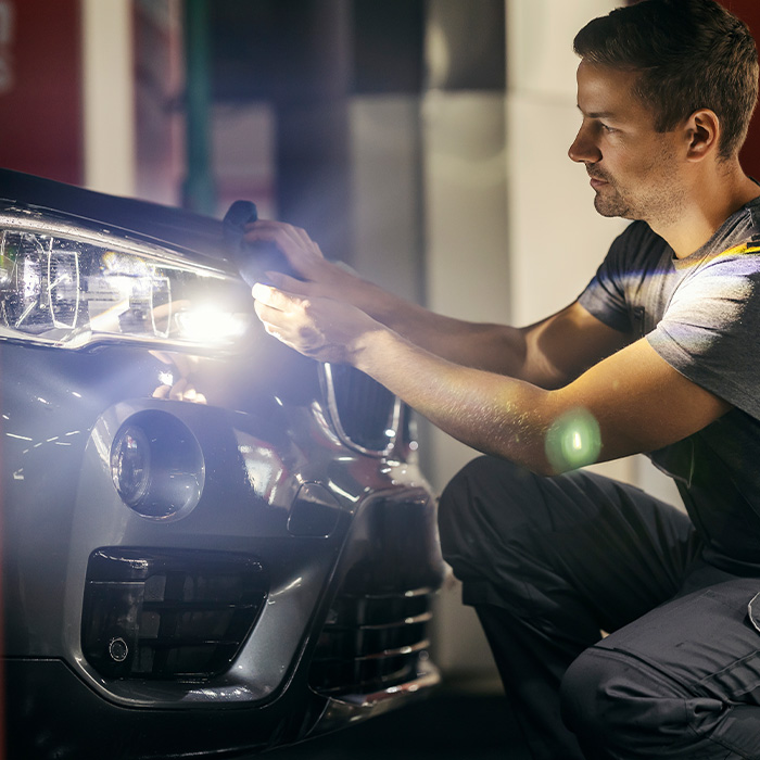 A car wash worker is polishing a car at station