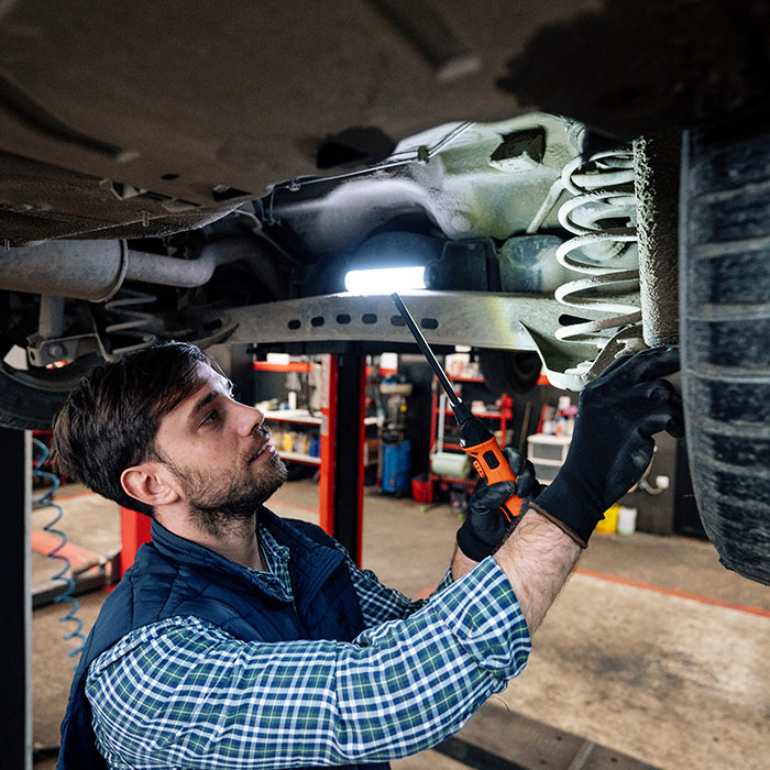 Car mechanic fixing or checking the car in workshop