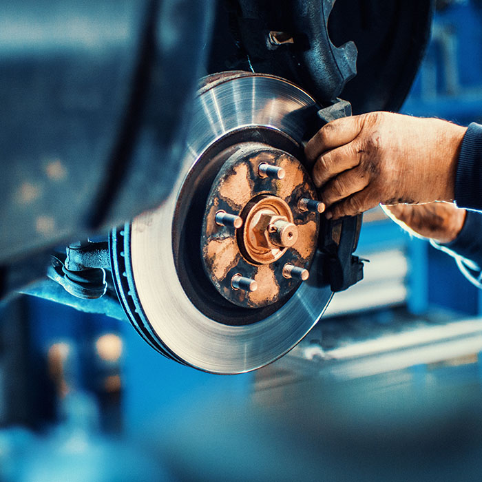 mechanic replacing car brake pads